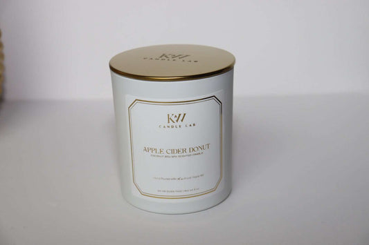 picture of a white candle with a gold lid with kw candle lab logo engraved in the lid