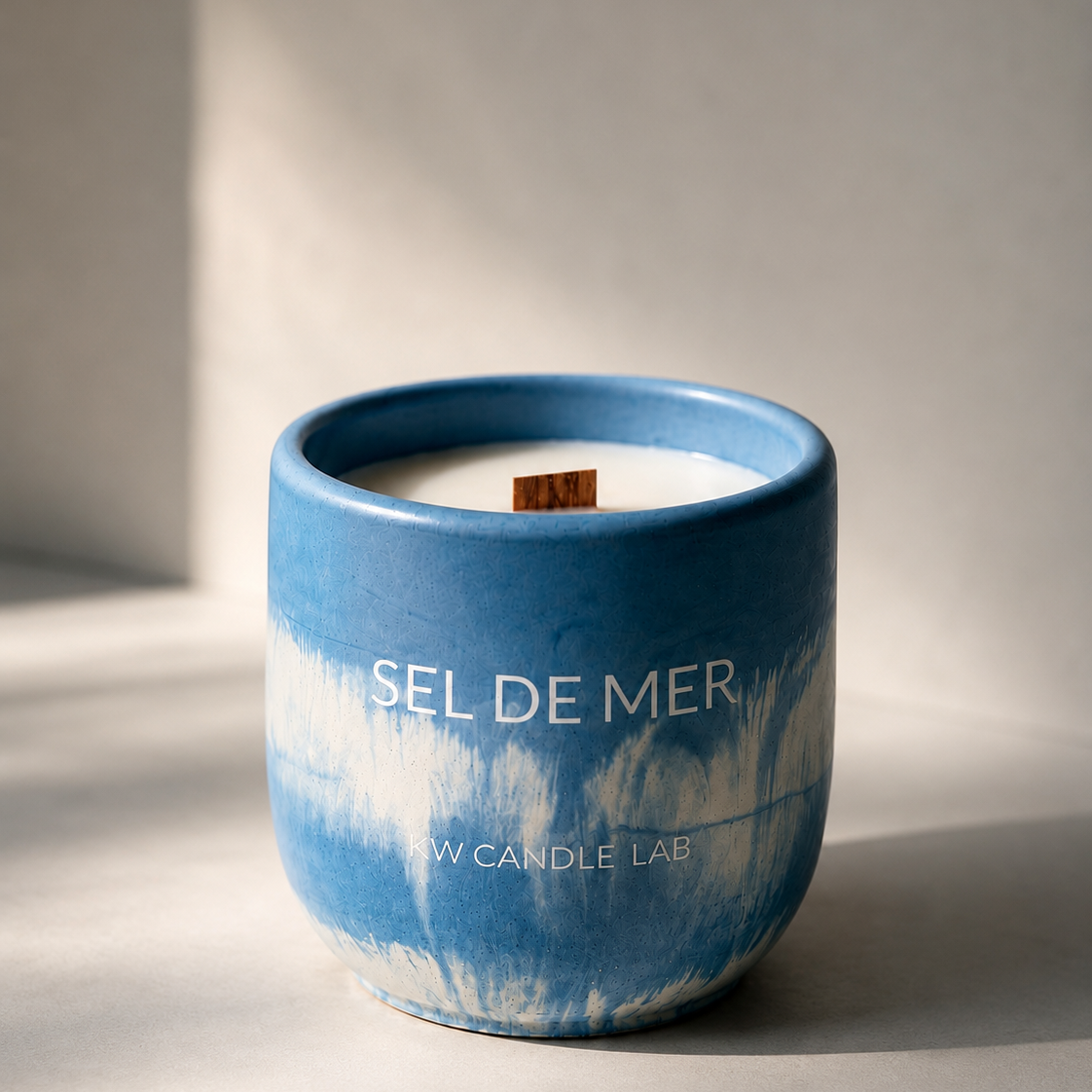 KW Candle Lab Blue and white concrete candle Sel de Mer' with wooden wick on a neutral background