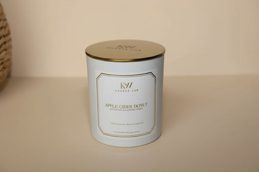 picture of a white candle with a gold lid with kw candle lab logo engraved in the lid