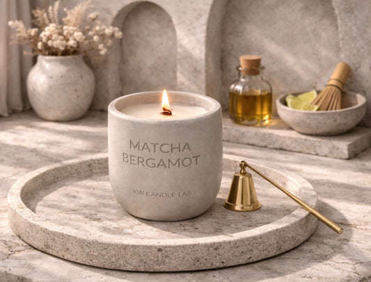 Matcha Bergamot candle on a stone tray with decorative items in the background