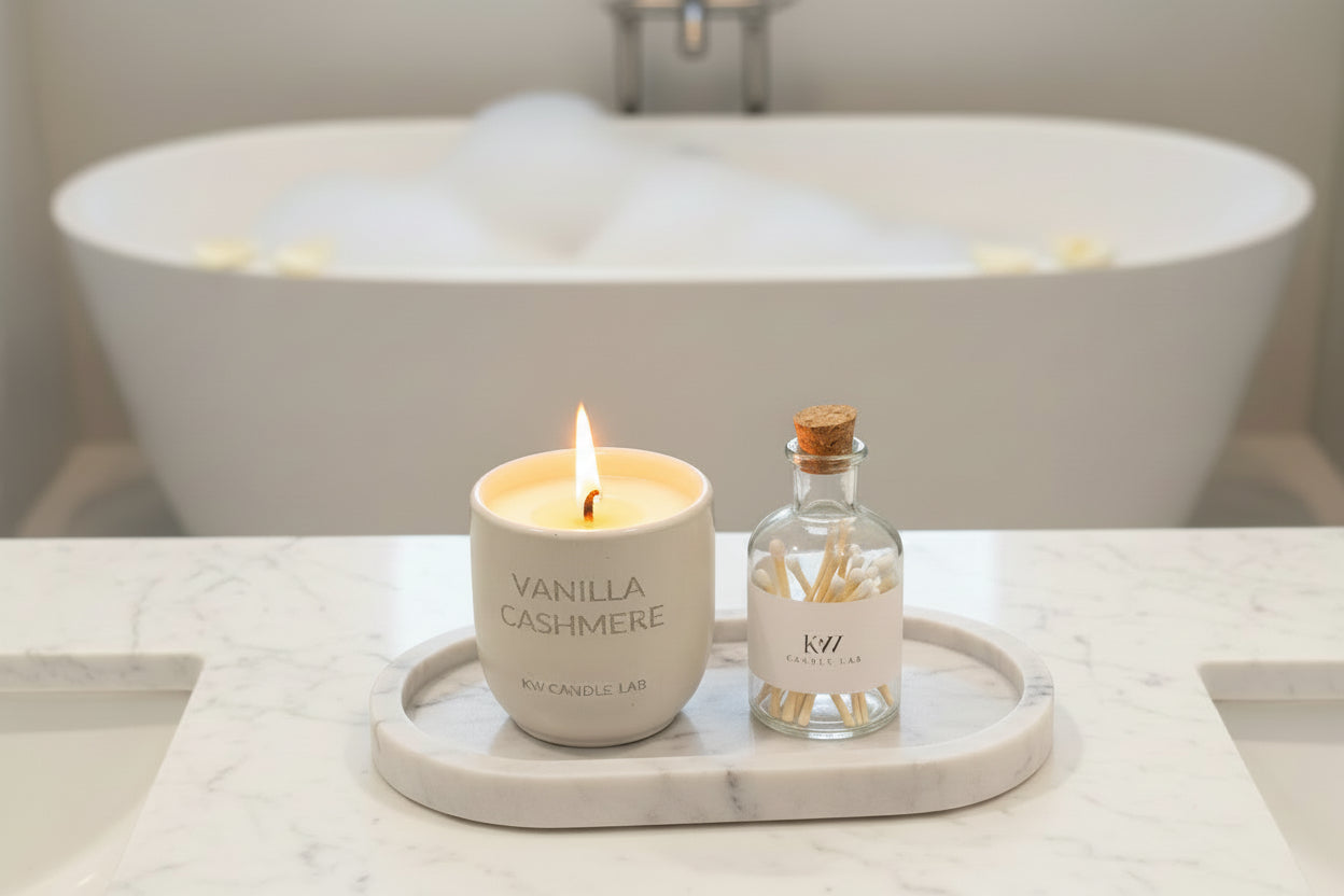 Vanilla Cashmere candle and matches on a tray with a bubble bath in the background