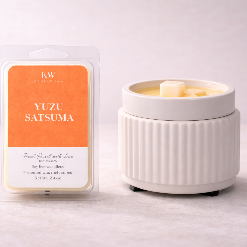 KW Candle Lab Yuzu Satsuma luxury wax melts beside a ceramic wax warmer for a bright, flameless home fragrance experience.